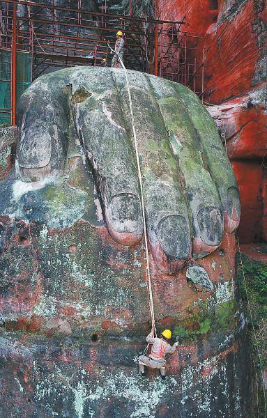 技術(shù)人員對大佛手部生長的植被進行清理